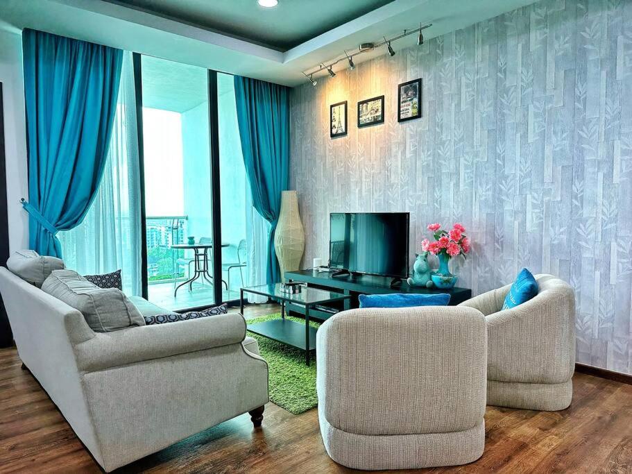 uma sala de estar com duas cadeiras e uma televisão em YM Homestay Vivacity megamall Jazz Suite 3 bedroom 8 pax em Kuching