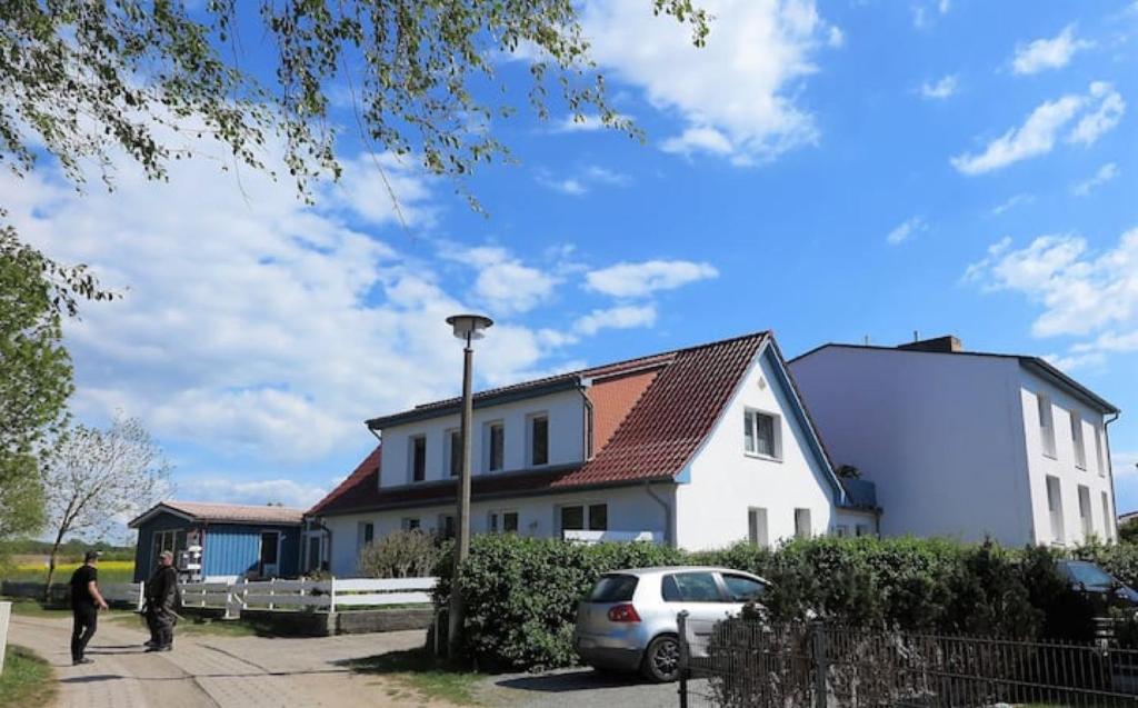 een wit huis met een auto ervoor geparkeerd bij Möve Aba Appartment 11 in Rerik