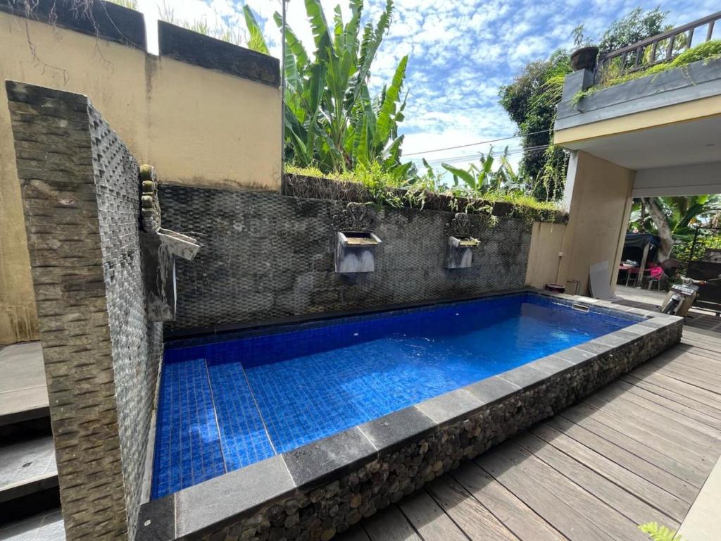 a swimming pool in the middle of a house at Sublime Seaside Villa Near Sunset Beach Tanah Lot in Tanah Lot
