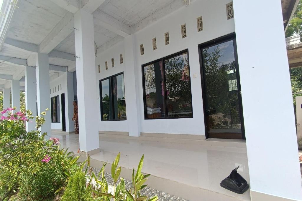 um edifício com janelas e plantas no chão em OYO 93638 Lotus Guest House em Lombok