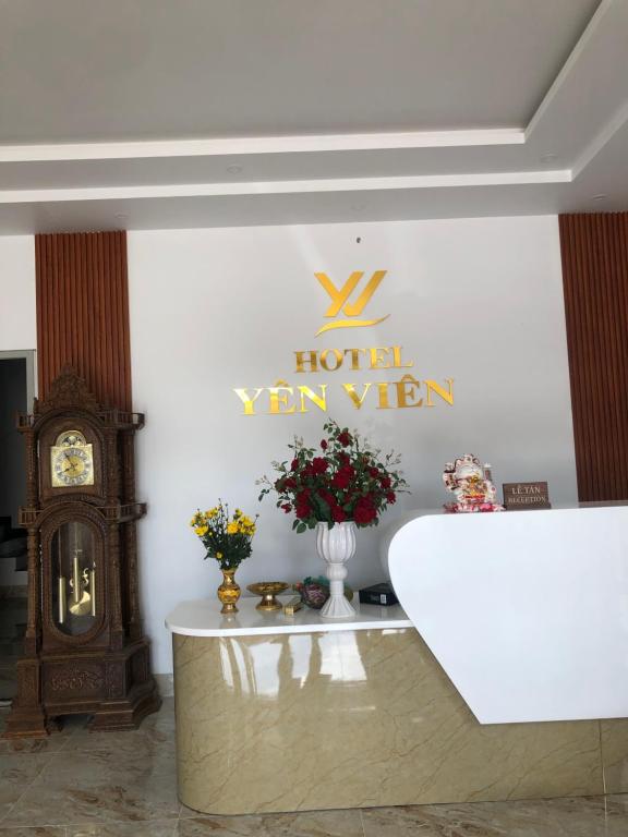 a hotel room with a clock and flowers on a wall at HOTEL YÊN VIÊN in Hoat