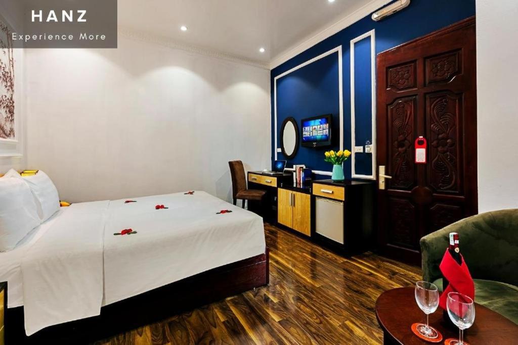 a hotel room with a bed and a table with wine glasses at Hanoi Local Homestay in Hanoi