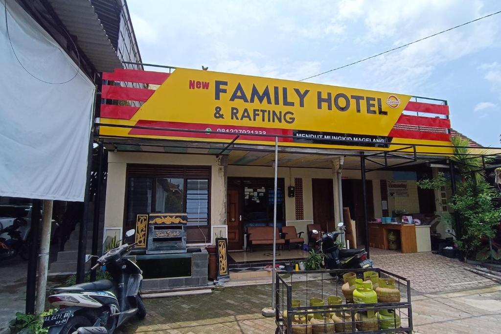 a family hotel with a yellow and red sign at OYO 93660 New Family Hotel Syariah in Magelang