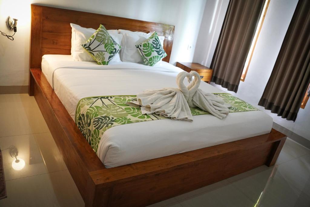 a bedroom with two beds with white sheets at Wahyu Masari Homestay in Nusa Penida