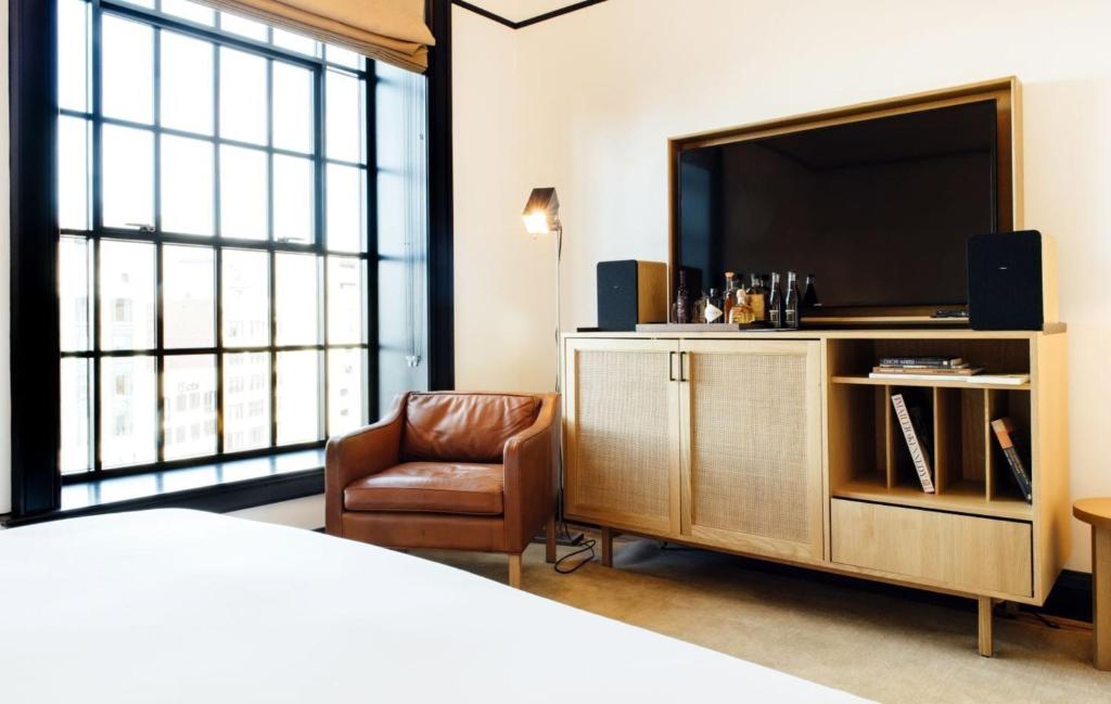 a hotel room with a bed and a television and a chair at Shinola Hotel in Detroit