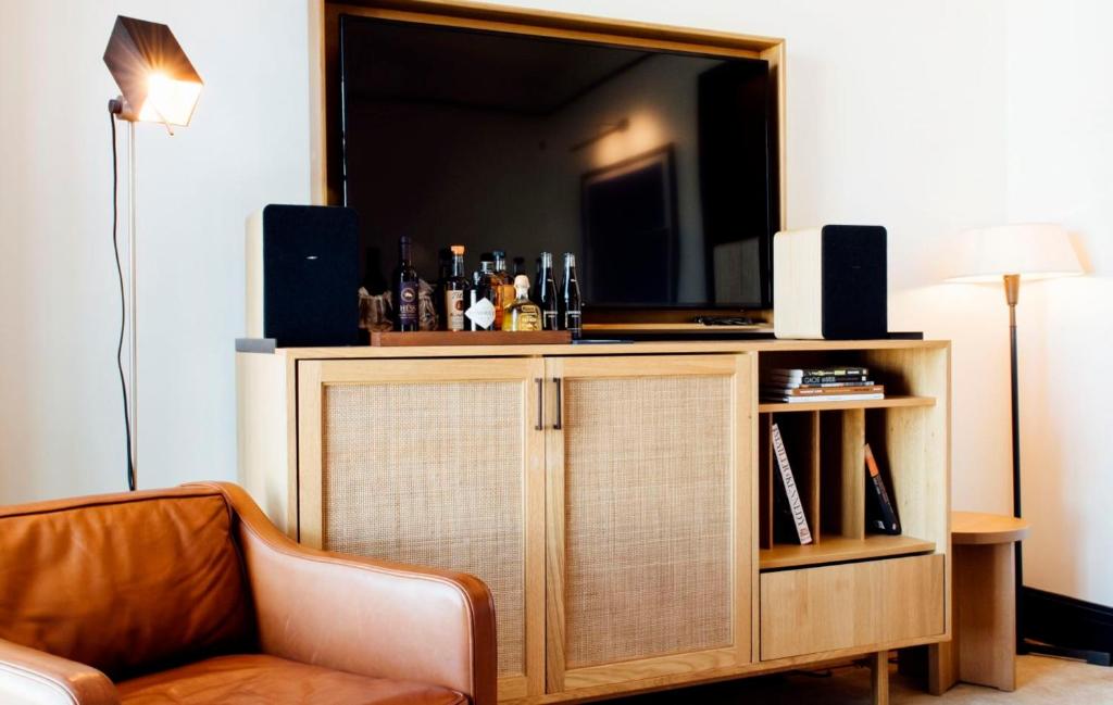 a living room with a entertainment center with a flat screen tv at Shinola Hotel in Detroit