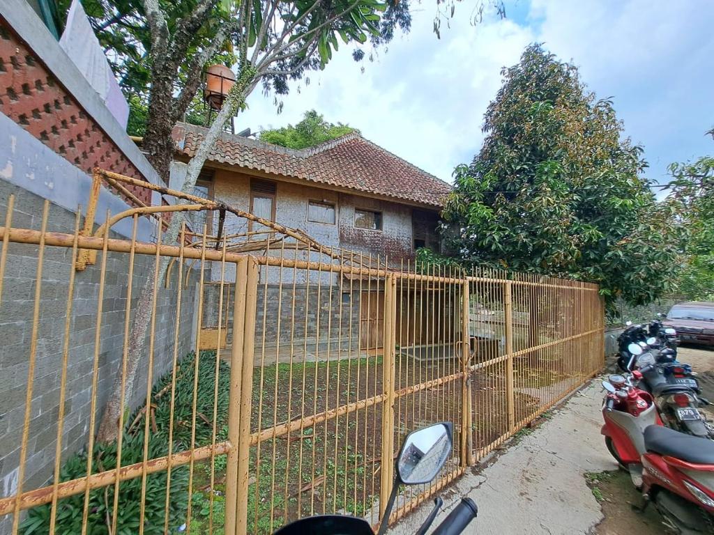 una cerca frente a una casa con motocicletas en OYO 93656 Villa Cassanova Syariah, en Garut