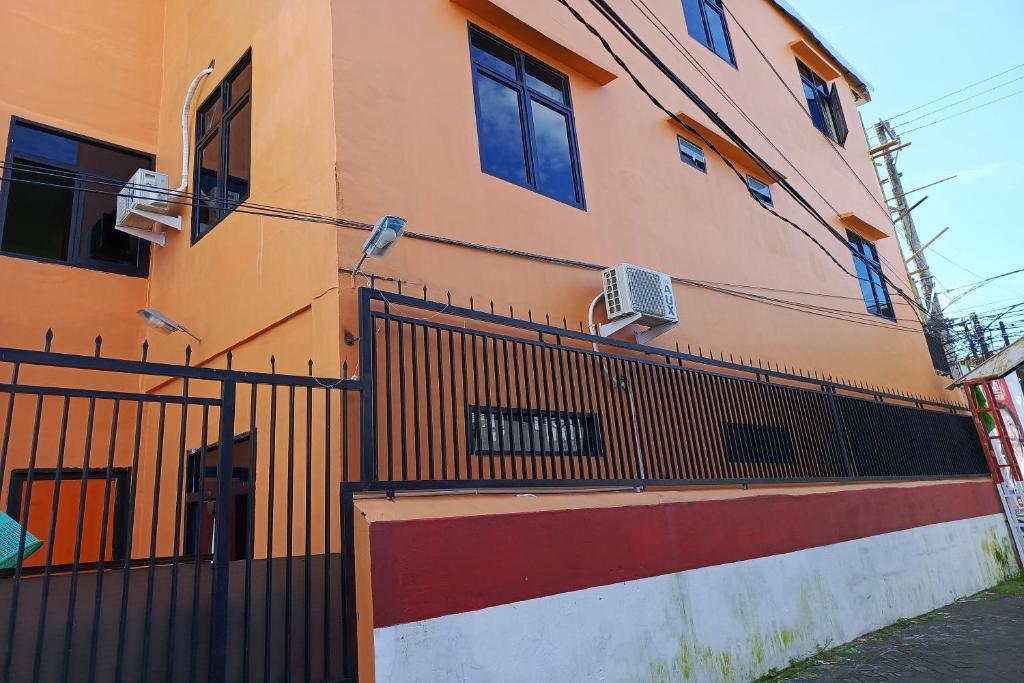 un edificio con una valla delante en OYO 93664 Homestay Purirano en Lepoleop