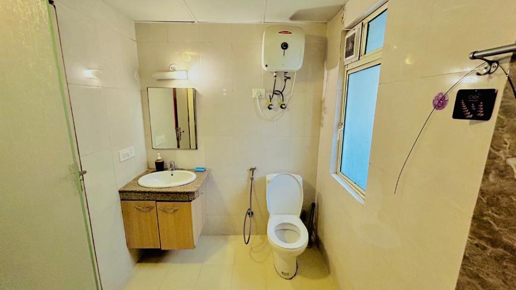 a small bathroom with a toilet and a sink at THE HONEY HOMES in Noida
