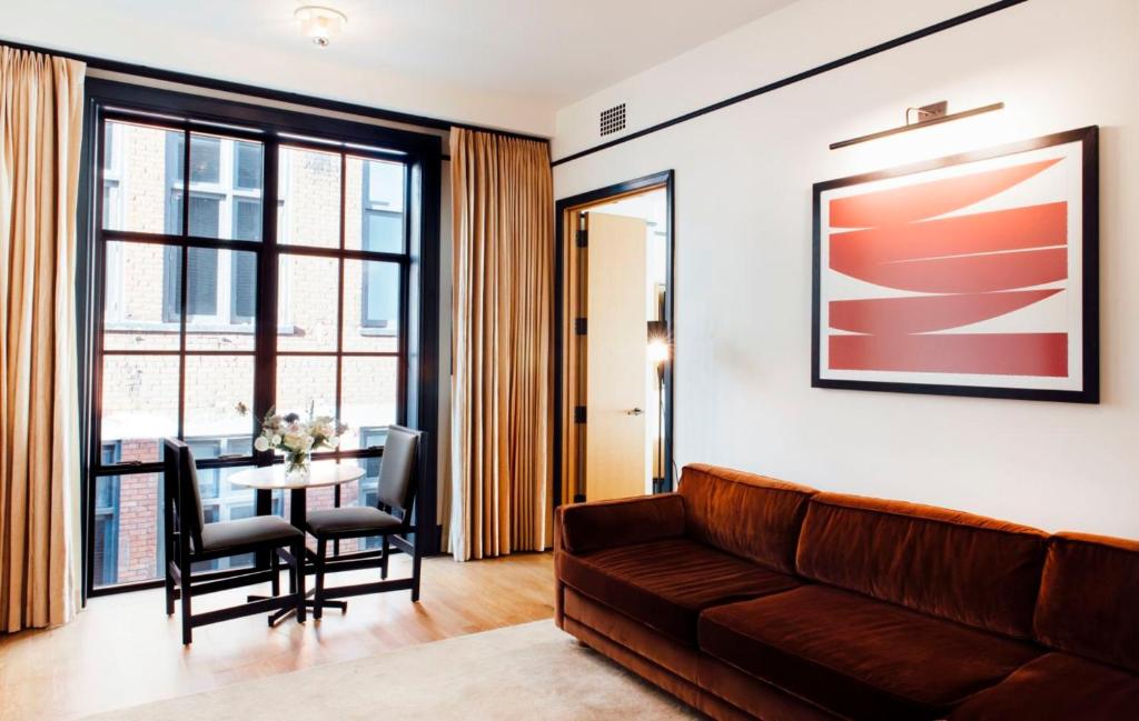a living room with a couch and a table with chairs at Shinola Hotel in Detroit