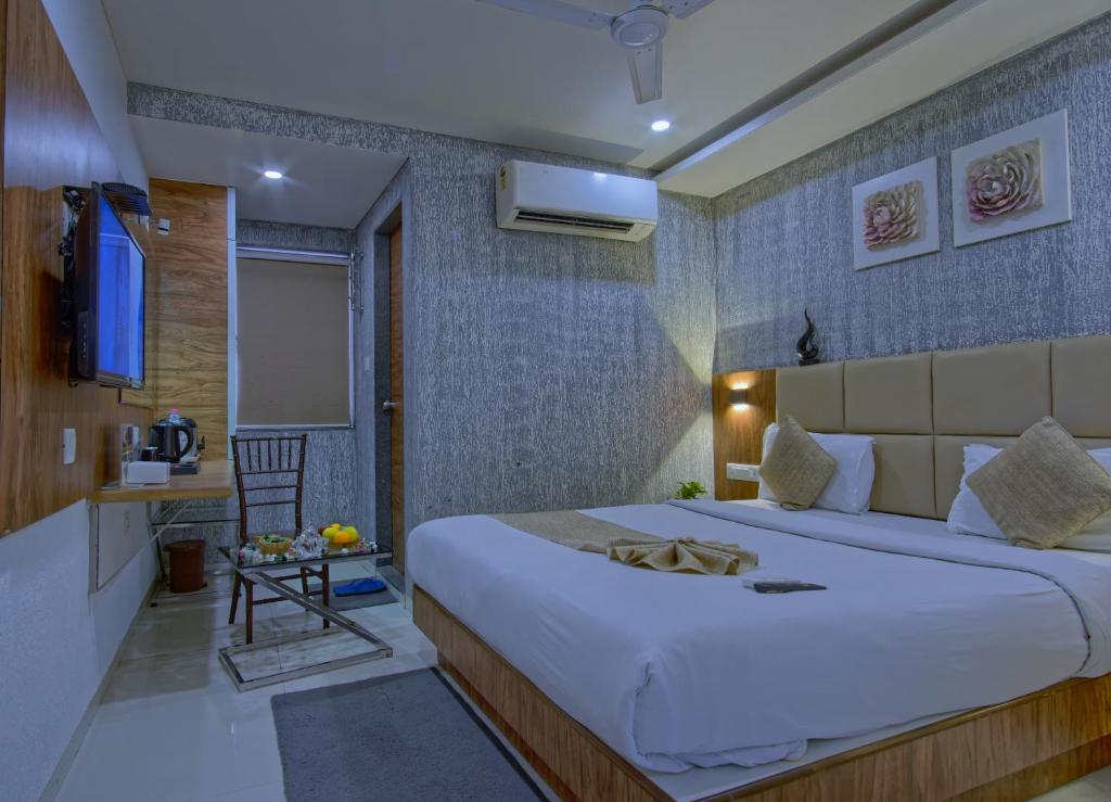 een slaapkamer met een groot bed in een kamer bij Hotel Limra in Surat