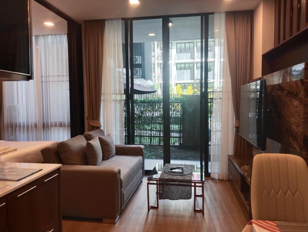 un soggiorno con divano e una grande finestra di Moutain & Pool view at Forest khaoyai a Pak Chong