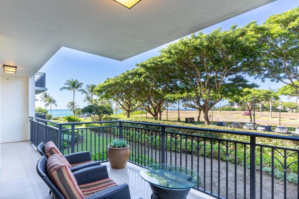 a balcony with two chairs and a table at Ko Olina Beach Villas B202 in Kapolei