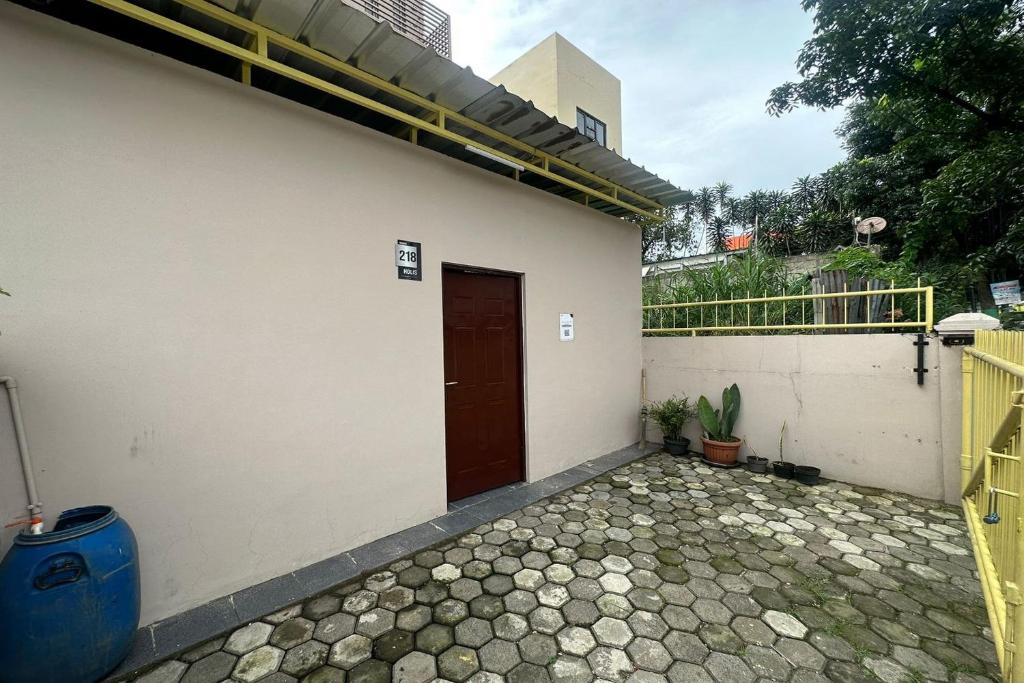 een wit gebouw met een deur en een patio bij SPOT ON 93624 Damai 3 Guest House Syariah in Bandung