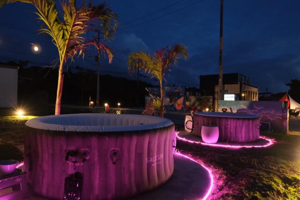 un grupo de luces púrpuras en un parque por la noche en 6月までの限定価格 海外のようなロケーションのコンテナ型ホテル, en Isla Miyako