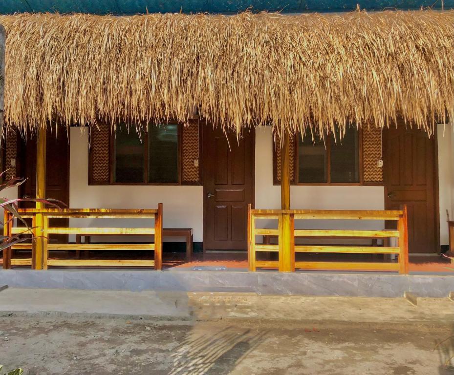 a hut with a straw roof and two benches at Hello Hostel in San Vicente