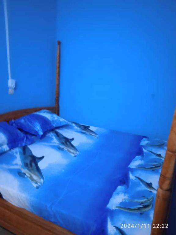 Una cama con dos delfines encima. en GL GUEST HOUSE, en Abomey