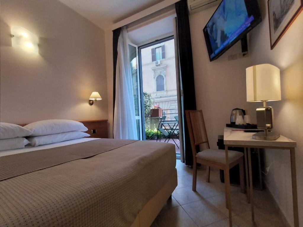 a bedroom with a bed and a window with a television at Hotel Principe Eugenio in Rome