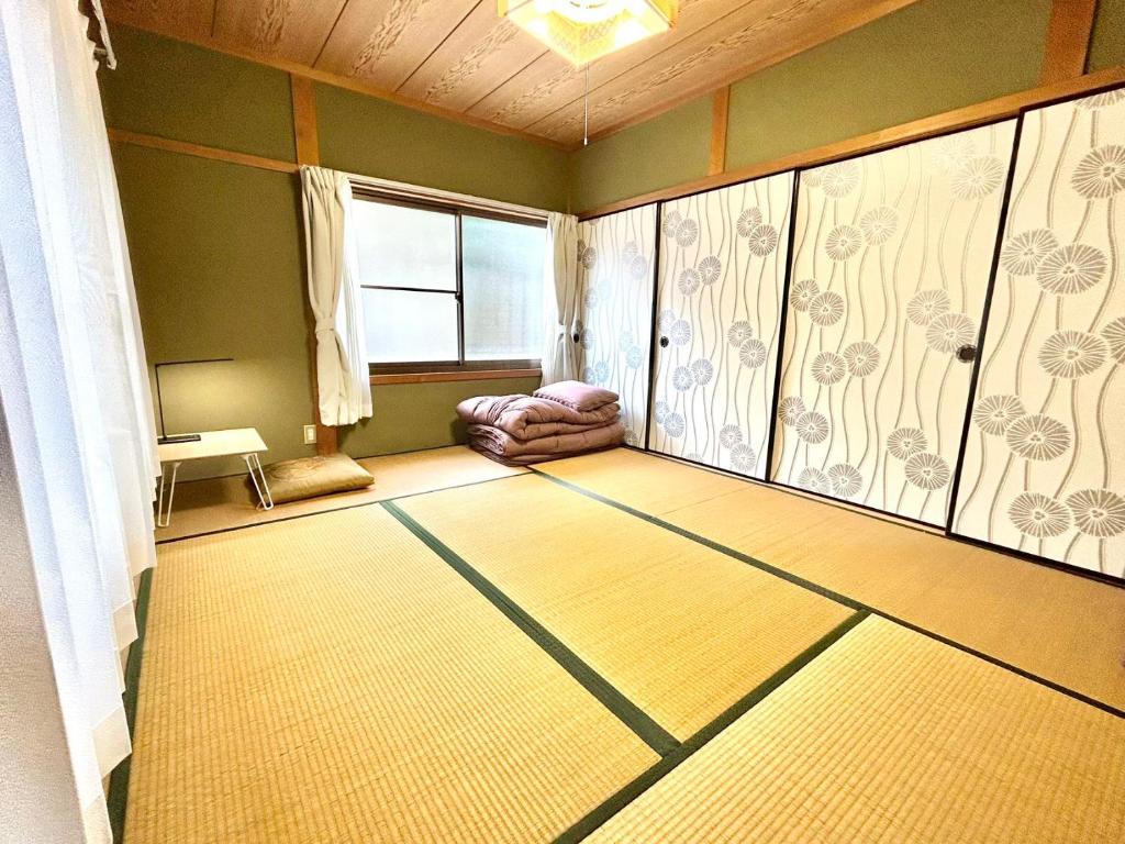 um quarto vazio com um tapete num quarto com uma janela em ゲストハウス 畔（hotori） 