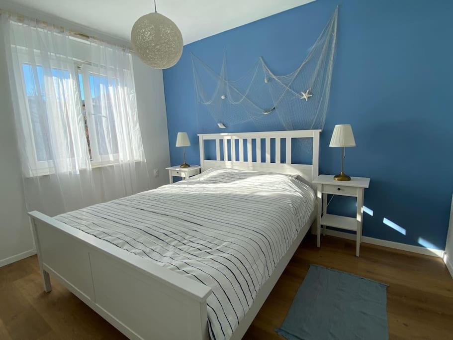 - une chambre dotée d'un lit avec un mur bleu dans l'établissement Captain's home ****, à Opatija
