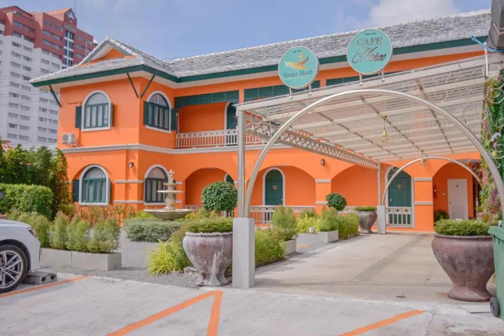 um edifício laranja com um arco em frente em Venice Hotel Hua Hin em Hua Hin