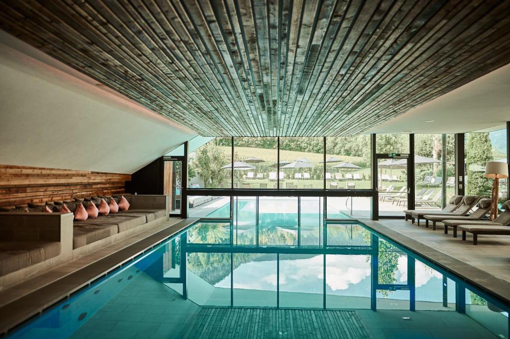 a house with a swimming pool with a large window at Hotel Petrus in Brunico