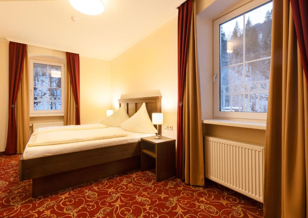um quarto de hotel com uma cama e uma janela em Appartements Feroli em Dienten am Hochkönig