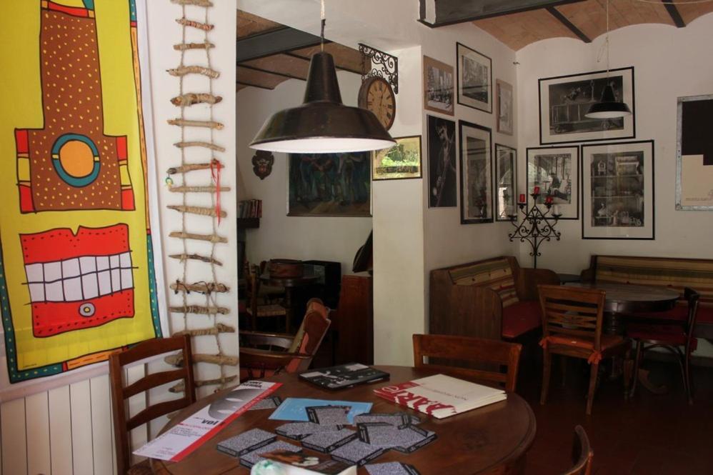 a dining room with a table and chairs and a clock at Locanda Laudomia in Manciano