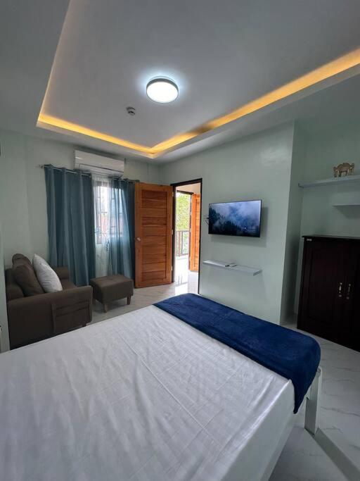 a bedroom with a large bed and a couch at Faith Street Airbnb in Plaridel