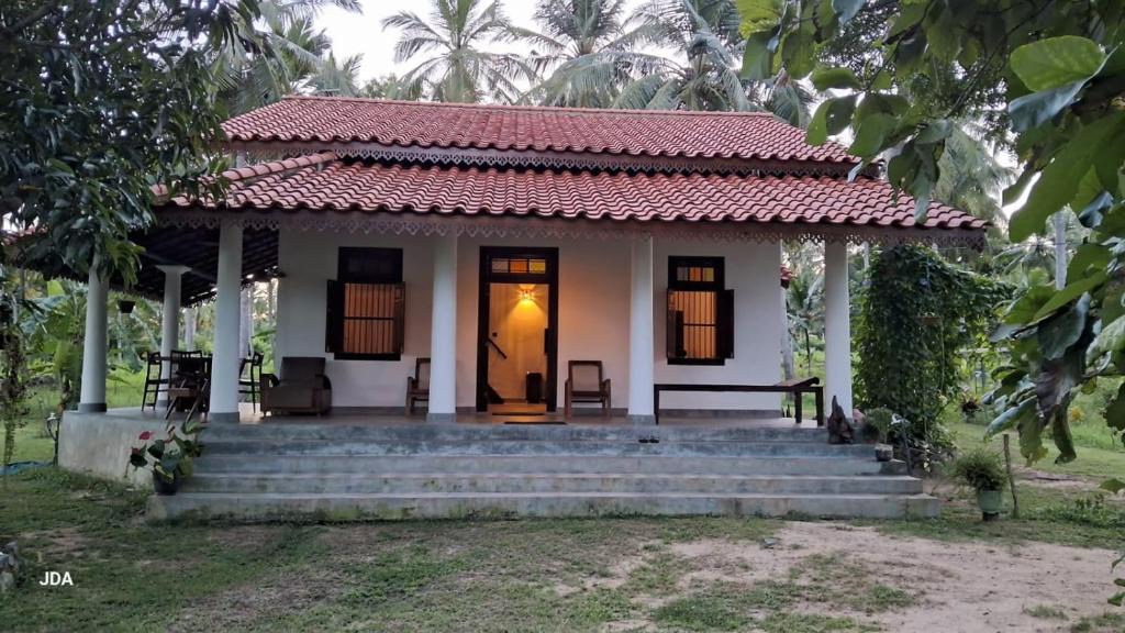 a small white house with stairs and a door at Antique Villa in Ranna