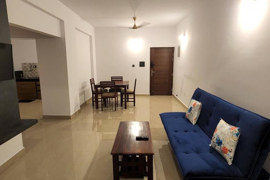 a living room with a blue couch and a table at 2bhk cozy apt near baina beach in Vasco Da Gama