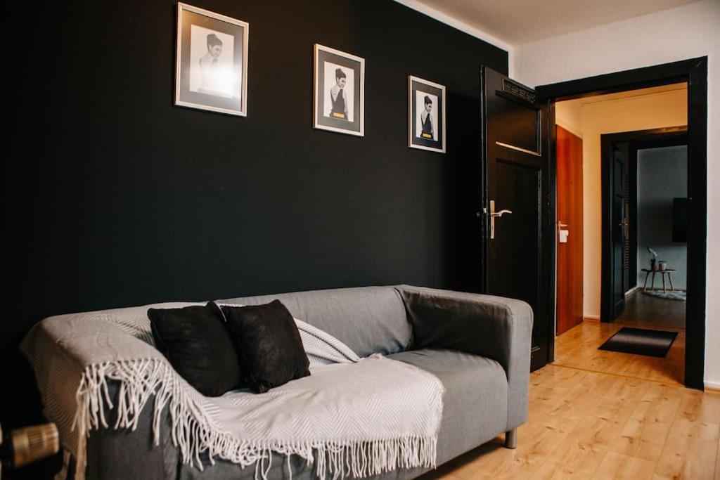 a living room with a gray couch with black walls at Modern & black - City - Netflix - Wifi - 4 Person in Bochum