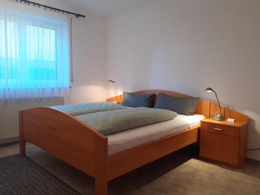 um quarto com uma cama com um candeeiro e uma janela em Ferienwohnung Frankenglück em Pretzfeld