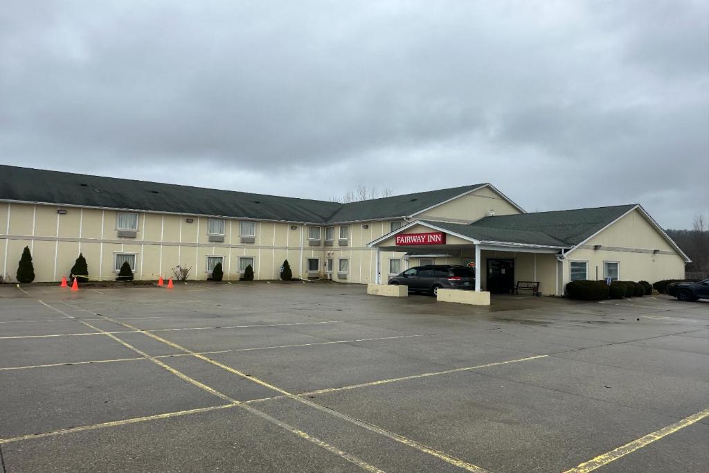 a large building with a parking lot in front of it at Fairway Inn Riverside By OYO Florence in Florence