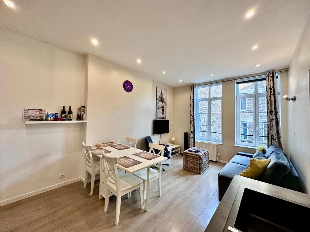 un salon avec une table et un canapé bleu dans l'établissement Escalille la Travia, à Lille