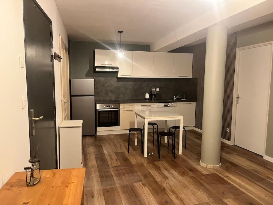 uma cozinha com mesa e cadeiras num quarto em Le 24 carat appartement 3 pièces neuf em Beaurepaire