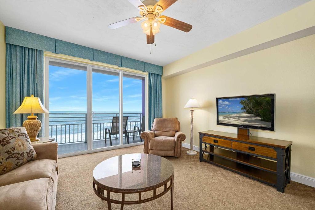 a living room with a television and a couch and a table at Beachfront Luxury Villa Ocean Walk Resort Daytona in Daytona Beach