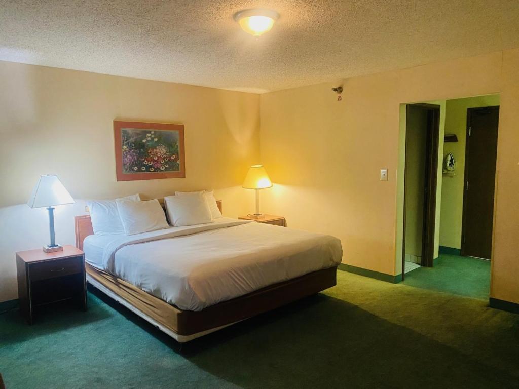 a bedroom with a large bed and two lamps on tables at Norwood Inn Statefare Grounds in Indianapolis