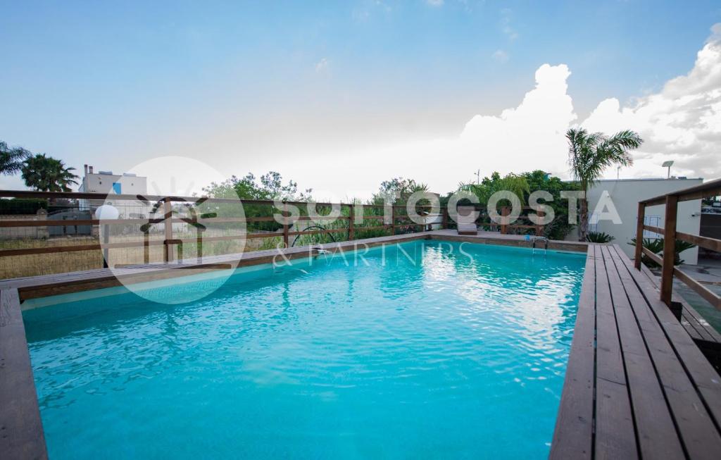 uma piscina com água azul num edifício em Blue Horizon - Residence with Pool em Porto Cesareo