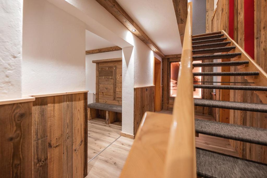 una escalera en una casa con paredes de madera y suelo de madera en Ferienhaus Marian, en Neustift im Stubaital