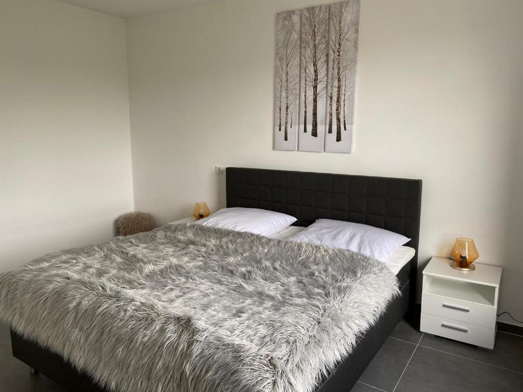 1 dormitorio con 1 cama con manta gris en Ferienwohnung PIER 1 in Cuxhaven, en Cuxhaven