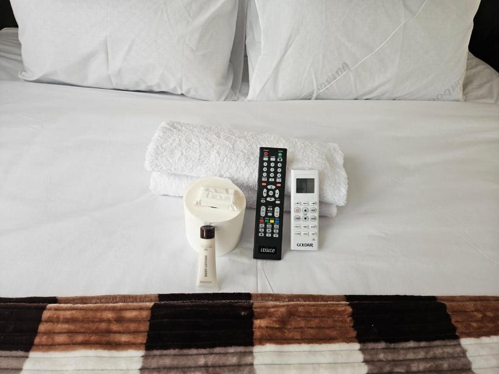 a remote control and a scale on a bed at DBright Lodge in Pretoria