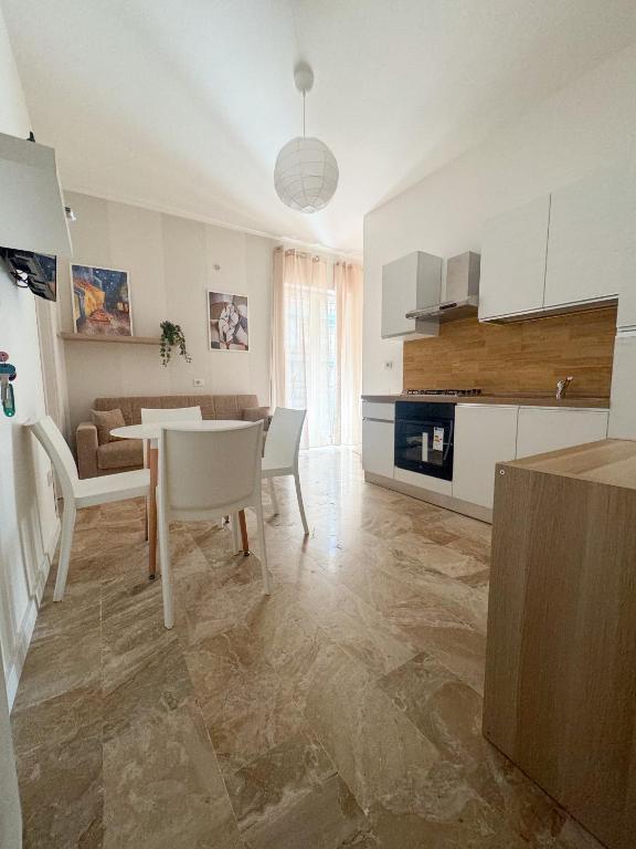 a kitchen and living room with a table and chairs at Living Room Orlando in Corigliano Calabro