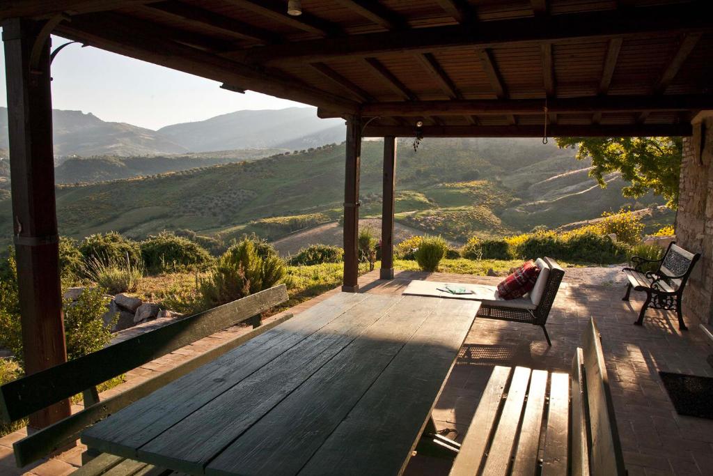 a porch with a bench and a view of the mountains at Azienda Agricola Pietra Pizzuta in Torre deʼ Passeri