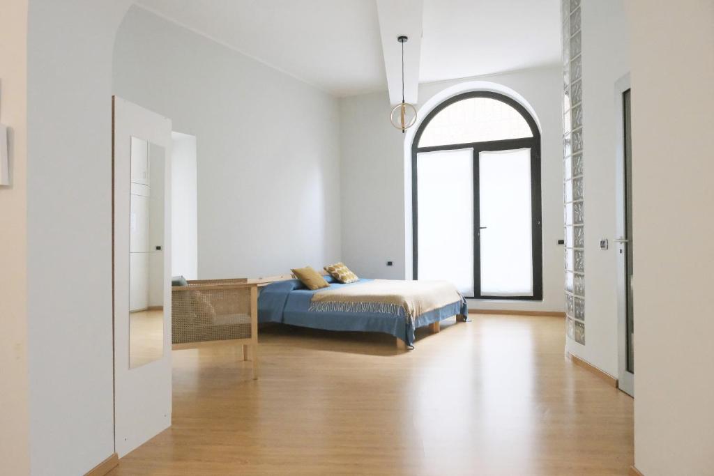 a bedroom with a bed and a table in a room at ComeCasa Bright City Flat with Private Terrace in Milan
