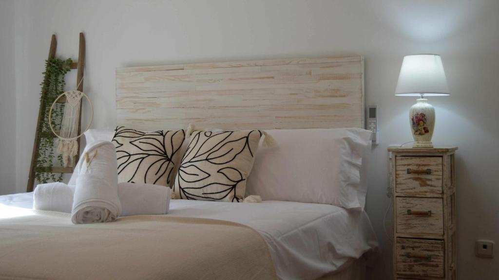 1 dormitorio con 1 cama con sábanas blancas y lámpara en Mahonia Palacio Congresos Parking Concertado en Granada