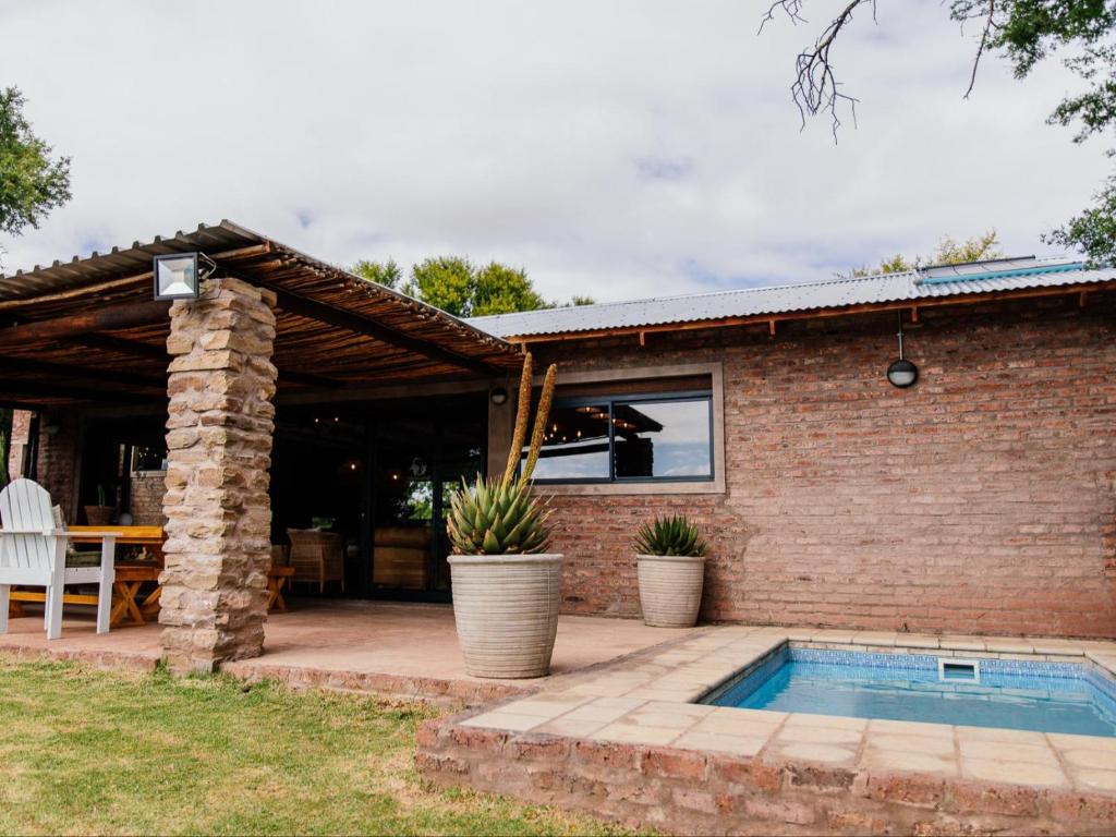 uma casa de tijolos com uma piscina em frente em Klipplaatsdrift Safari Lodge em Hofmeyr