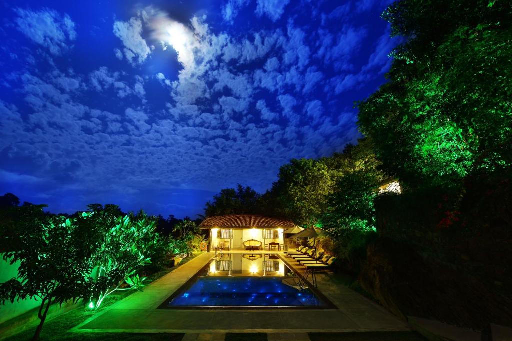 a house with a swimming pool at night at The Horizon Hill Top Villa in Unawatuna