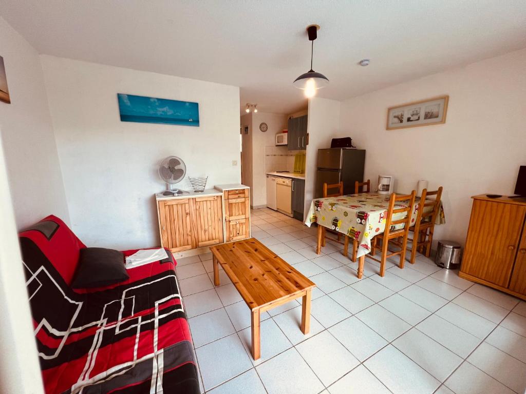 un salon avec une table et une cuisine dans l'établissement AZUREVA II Joli 2 pièces cabine piscine Richelieu Cap d'Agde, au Cap d'Agde