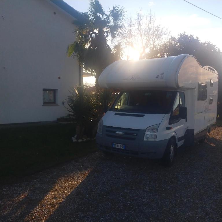 Ein weißer Truck parkt vor einem Haus. in der Unterkunft Mimoza Camper in Bibione